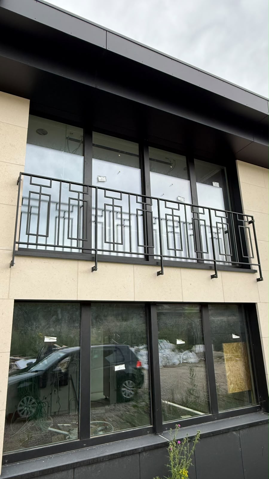Garde-corps de balcon noir à motif de rectangles, fixé en façade