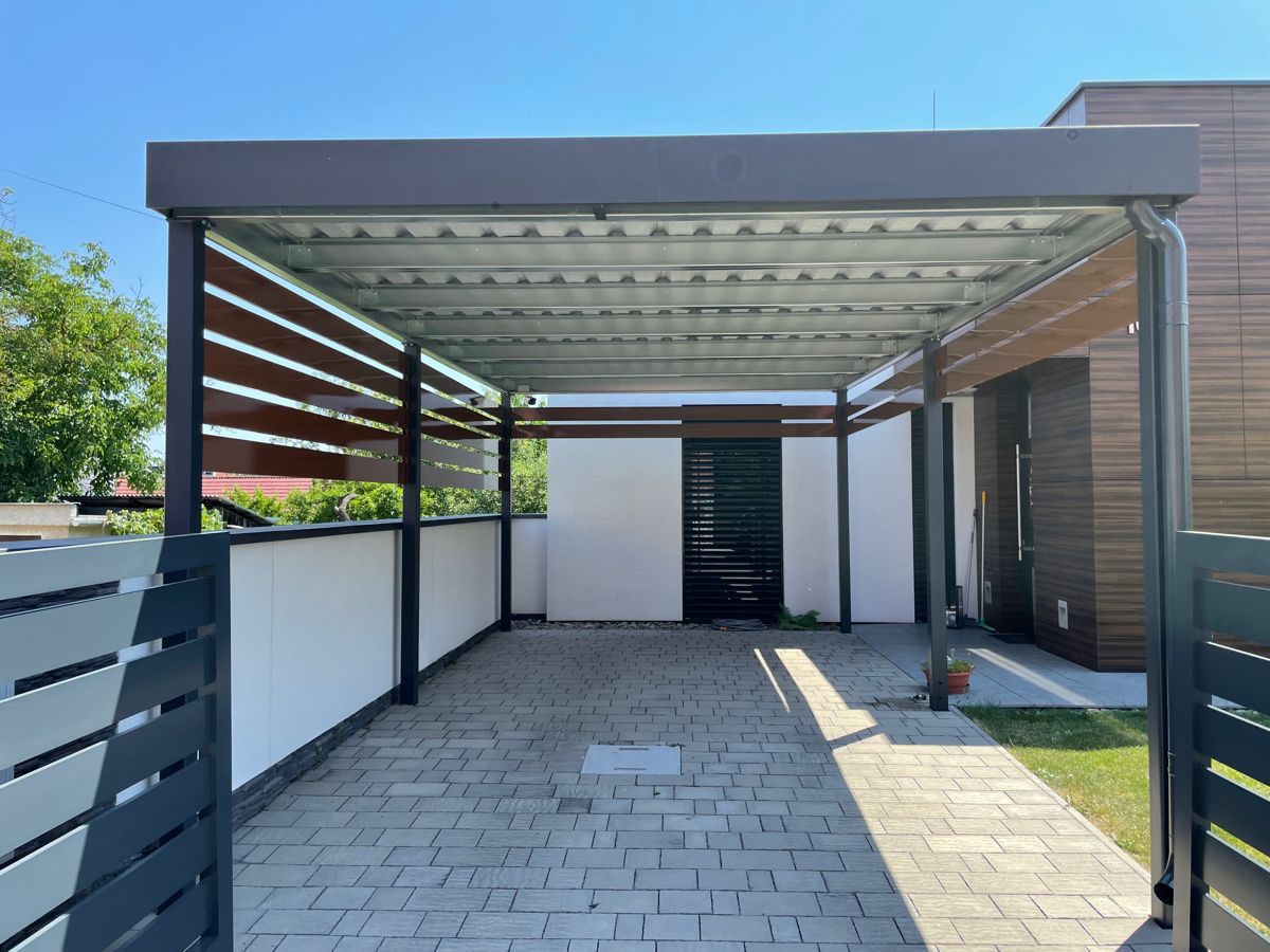Pergola métallique à lames de toiture et brise-vue, sur une terrasse pavée