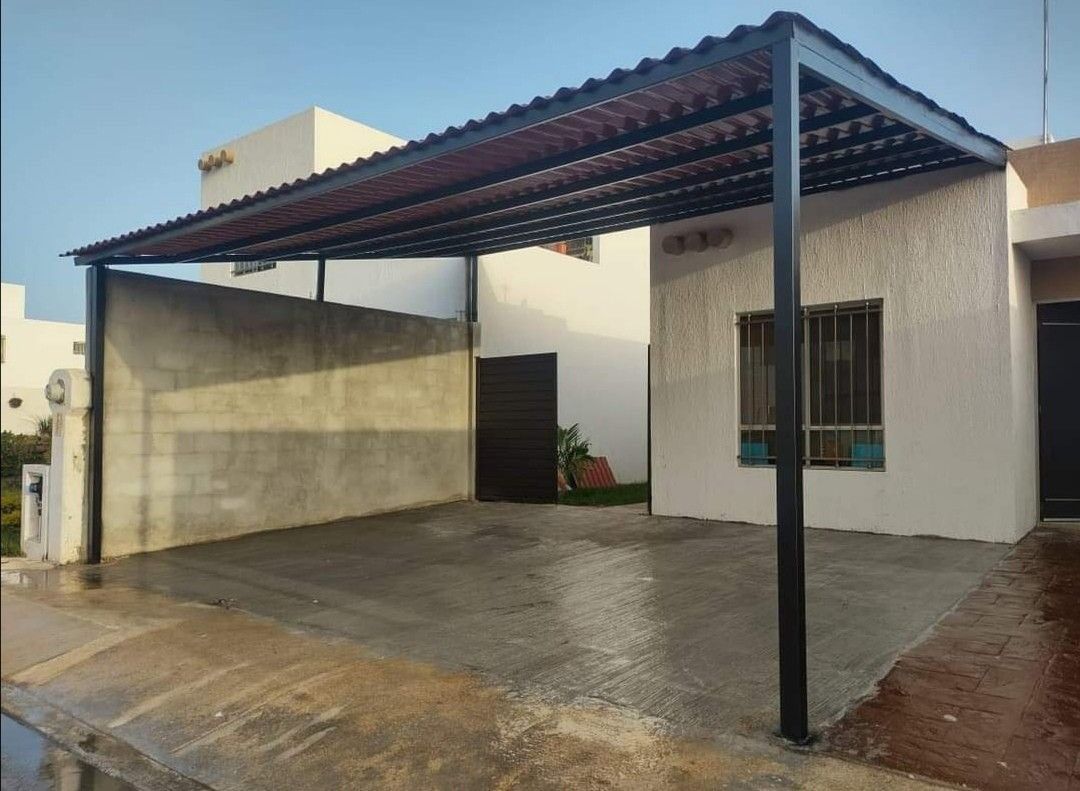 Structure métallique de carport à couverture ondulée devant une maison