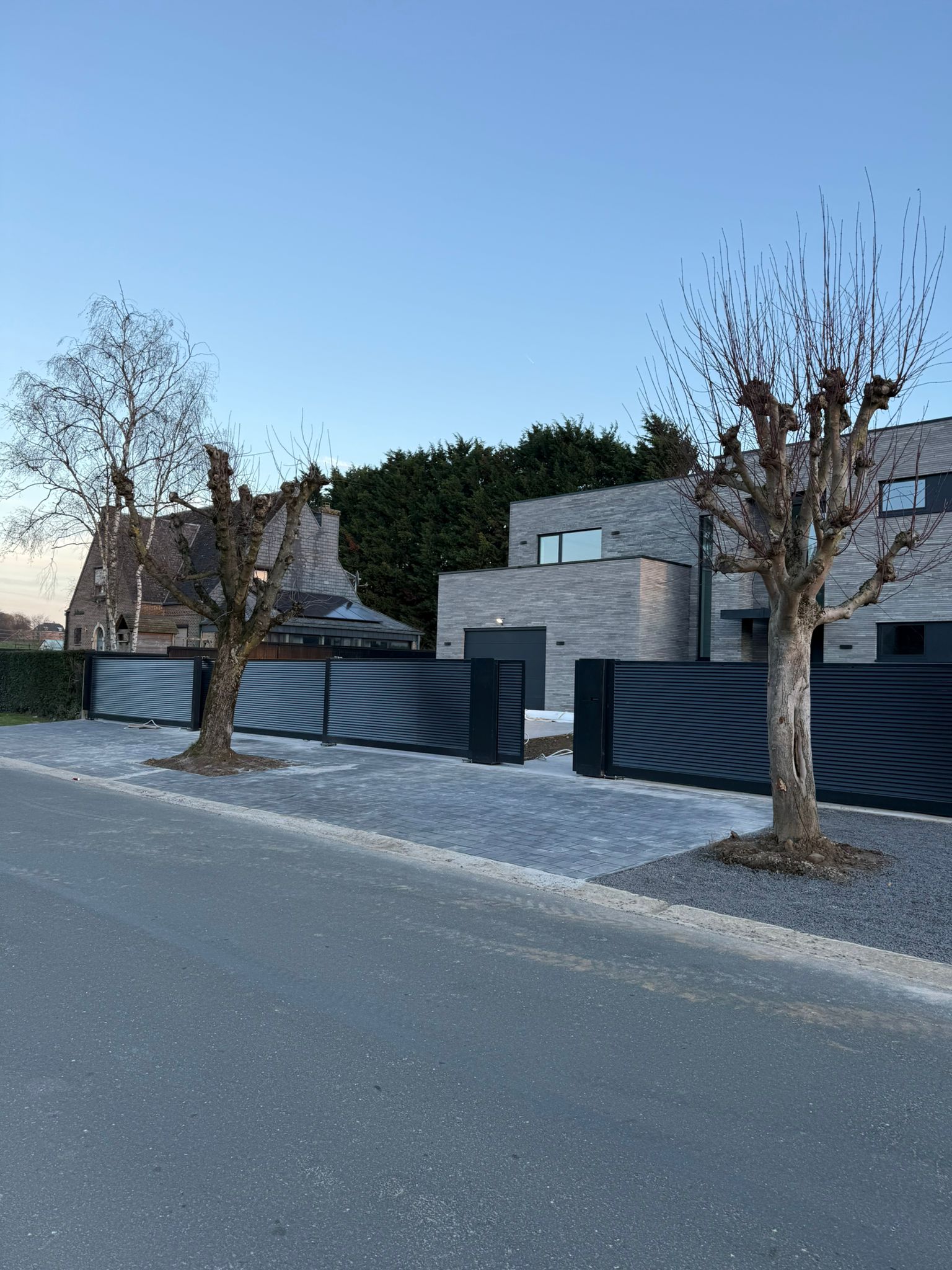 Portail coulissant anthracite à lames horizontales, avec portillon, devant une maison contemporaine