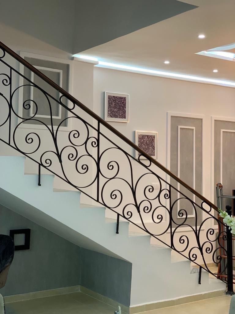 Rampe d’escalier intérieur entièrement ornée de volutes forgées