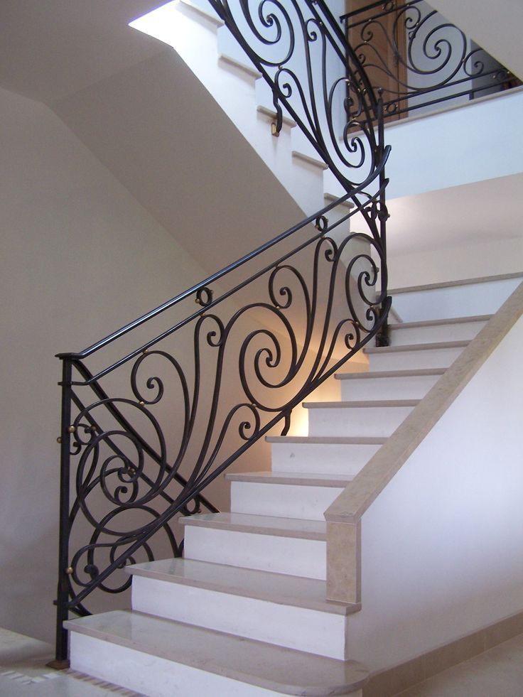 Rampe forgée à volutes et perles sur un escalier tournant